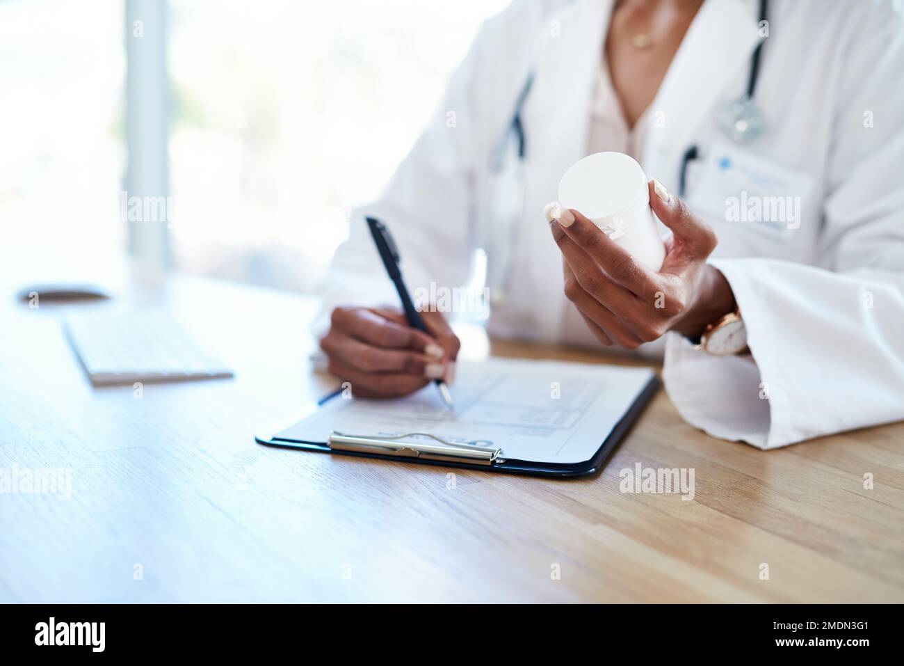 La vostra salute è nelle sue mani. un giovane medico che compila un modulo per una prescrizione medica nella sua sala di consulenza. Foto Stock