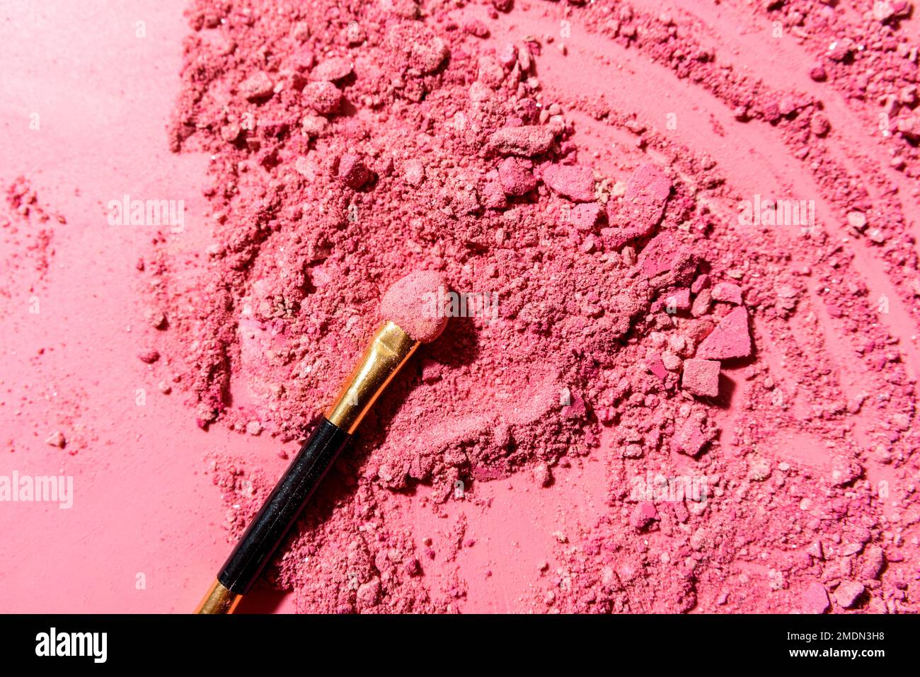 Ombre oculari rosa schiacciate con pennello o strumento di miscelazione applicatore su sfondo rosa Foto Stock