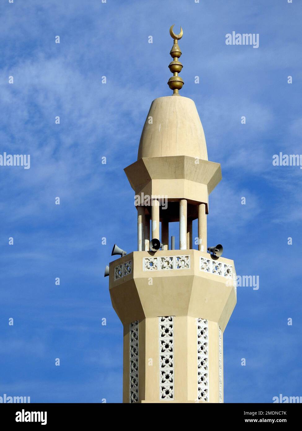 Un alto minareto di una moschea contro un bel cielo blu con nuvole alla luce del giorno, le Moschee sono il luogo di culto e di preghiere per i musulmani dove loro Foto Stock