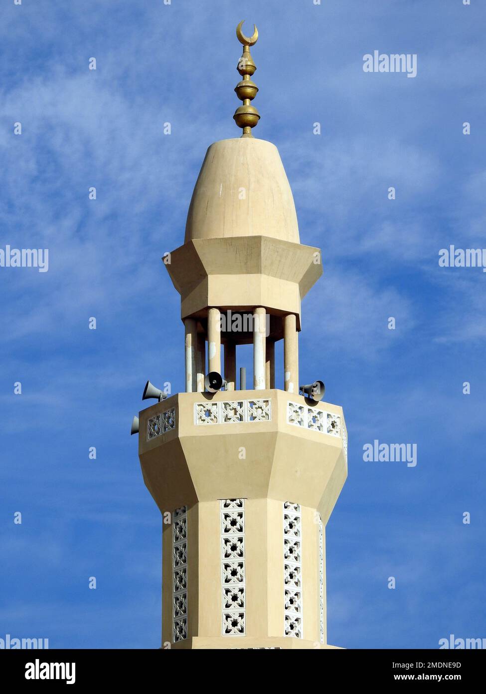 Un alto minareto di una moschea contro un bel cielo blu con nuvole alla luce del giorno, le Moschee sono il luogo di culto e di preghiere per i musulmani dove loro Foto Stock