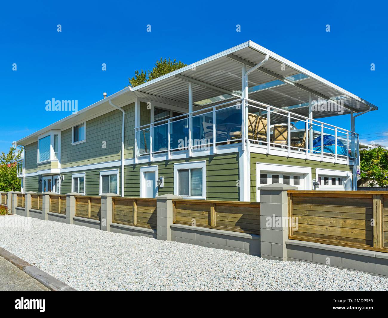 Nuova casa residenziale con recinzione in legno lungo una strada Foto Stock