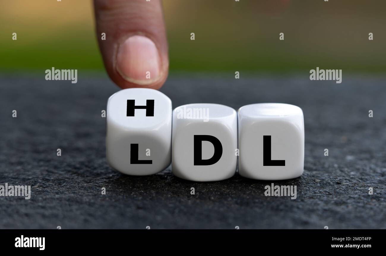 La mano gira i dadi e cambia l'abbreviazione LDL (lipoproteina a bassa densità) in HDL (lipoproteina ad alta densità). Foto Stock