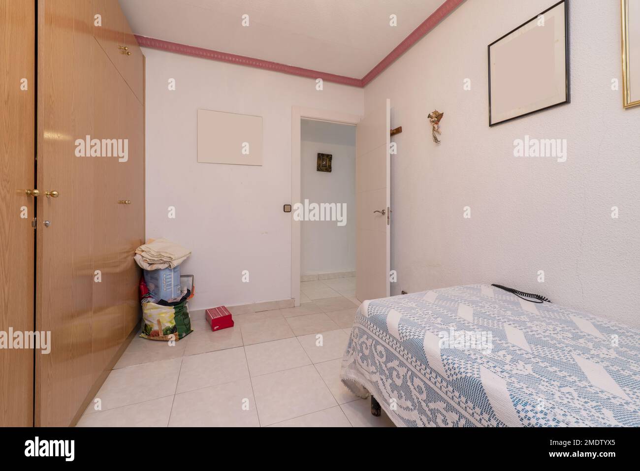 Camera con letto singolo e armadio a muro realizzato su misura che copre completamente una parete Foto Stock