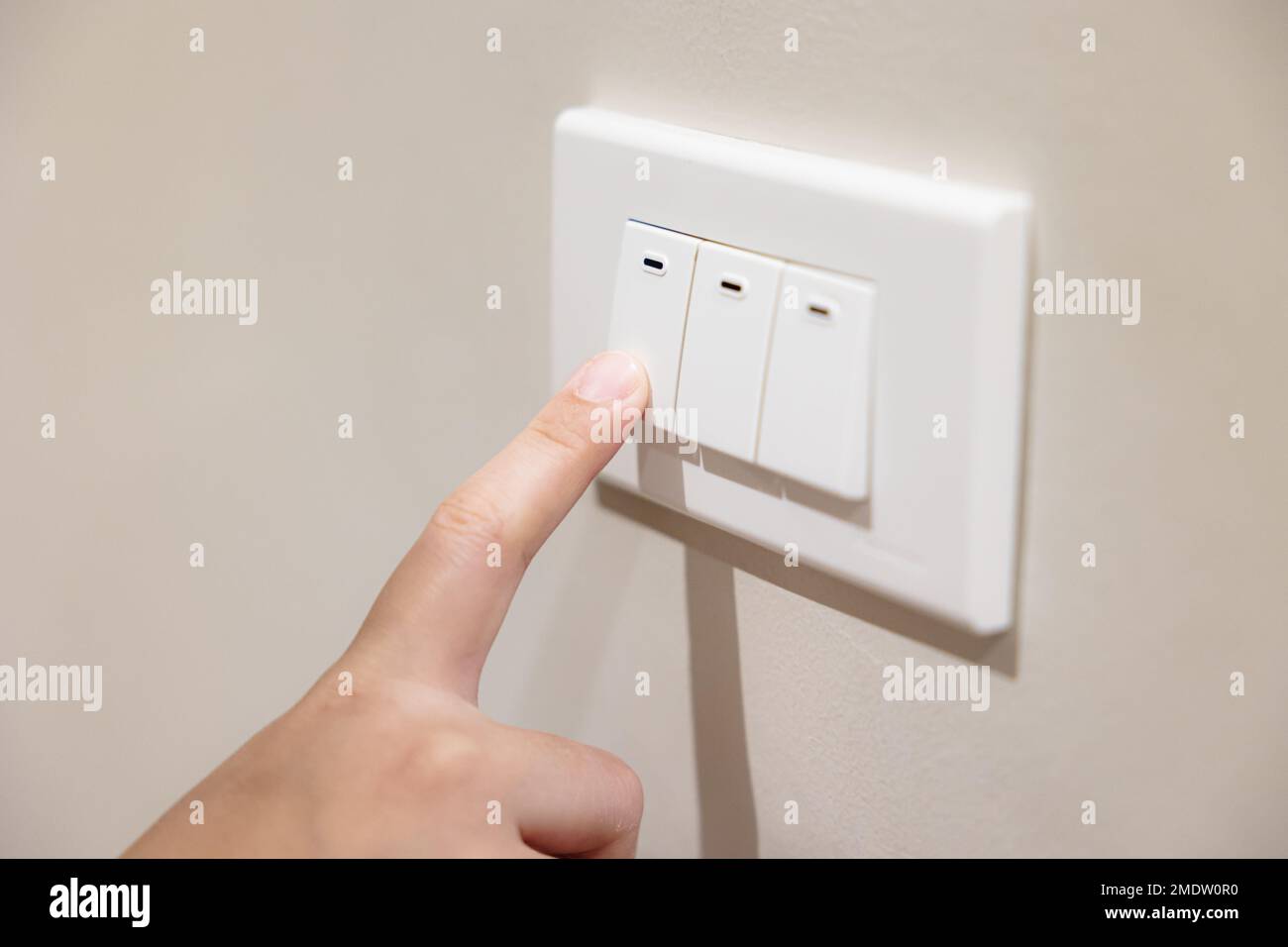 le persone premono l'interruttore della luce per spegnere la luce per risparmiare energia a casa ridurre i costi di fatturazione delle utenze Foto Stock