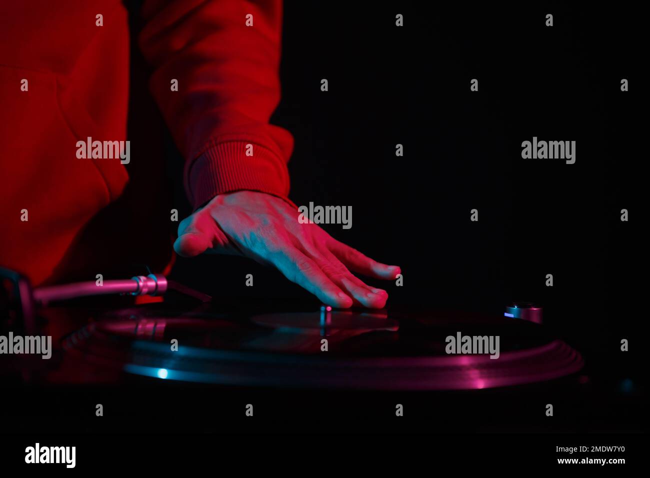 Disco jockey graffiare il disco in vinile sul giradischi giocatore. Hip hop DJ suona musica durante la festa nel night club Foto Stock