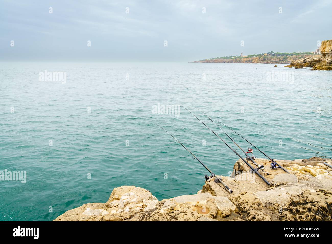 Canne da pesca sulle rocce della costa di Cascais, Portogallo Foto Stock
