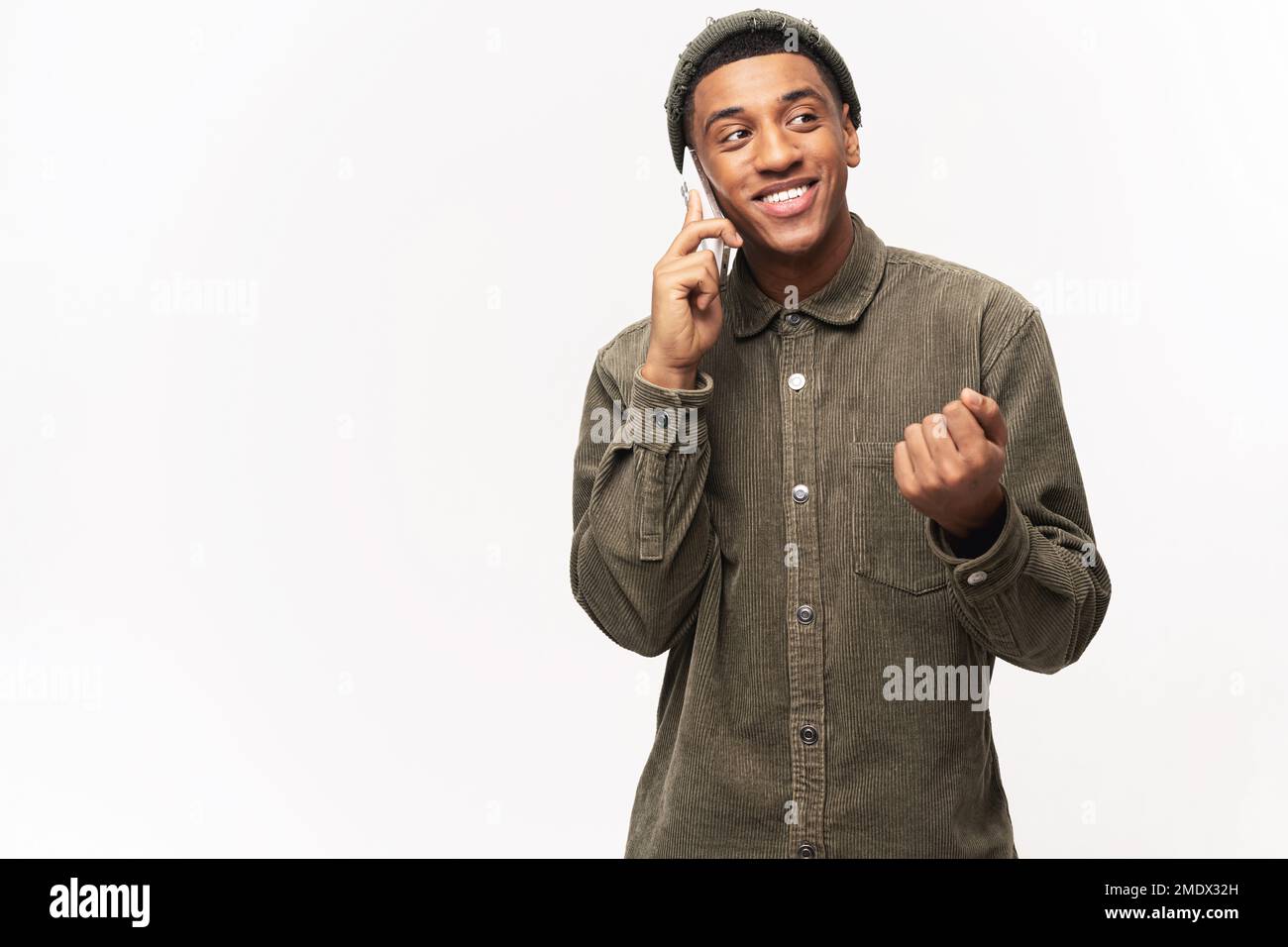 Giovane afro-americano spensierato che parla su smartphone isolato su sfondo bianco, avendo conversazione telefonica, uomo allegro indossare camicia casual chattare Foto Stock