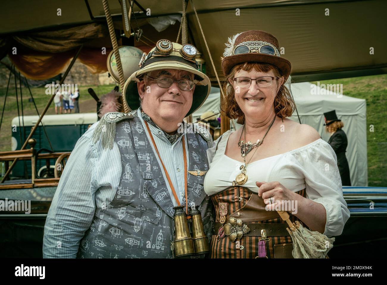 Una coppia steampunk di mezza età sorride direttamente alla macchina fotografica. Concetto di viaggio, avventura, attivo, esploratore. Foto Stock
