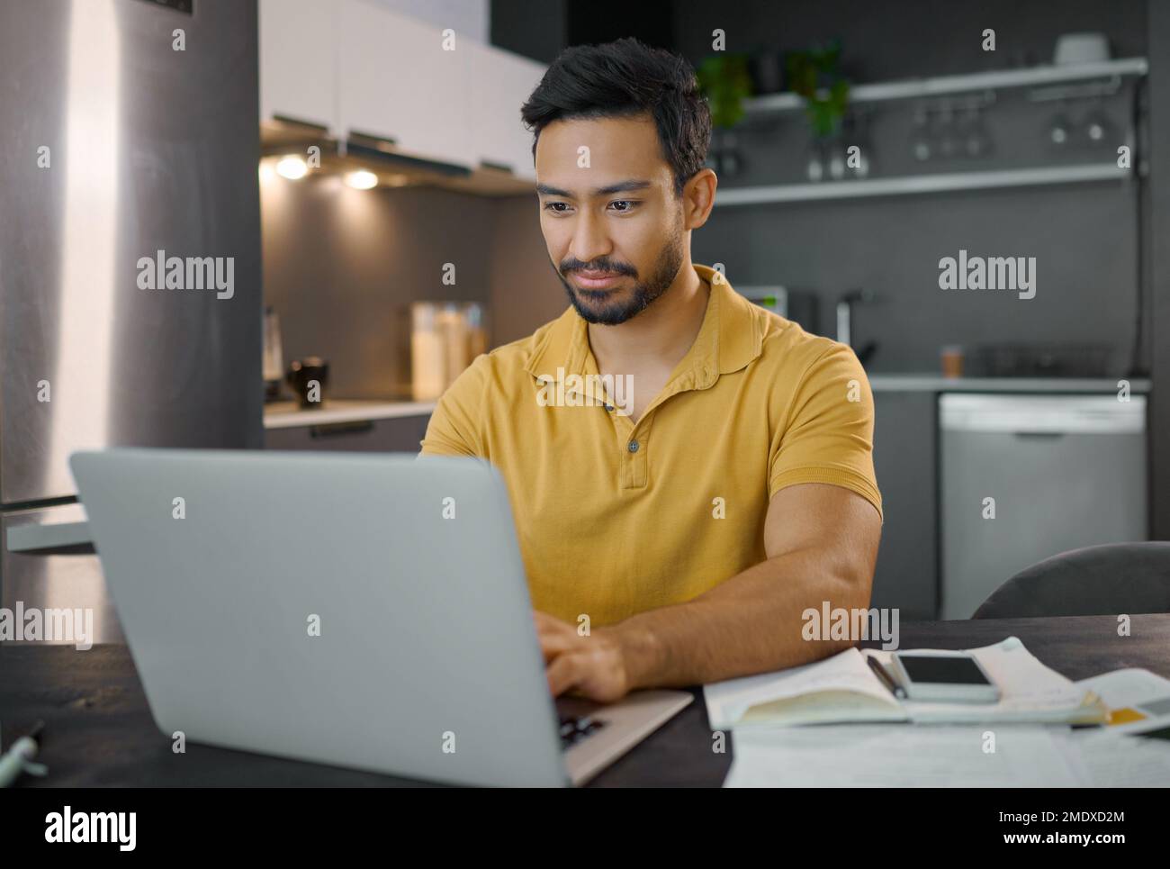 Uomo, lavoro remoto e computer portatile con la digitazione, copywriter scrivere articolo con ricerca su Internet con wi-fi in appartamento. Copywriting, creativo e SEO Foto Stock