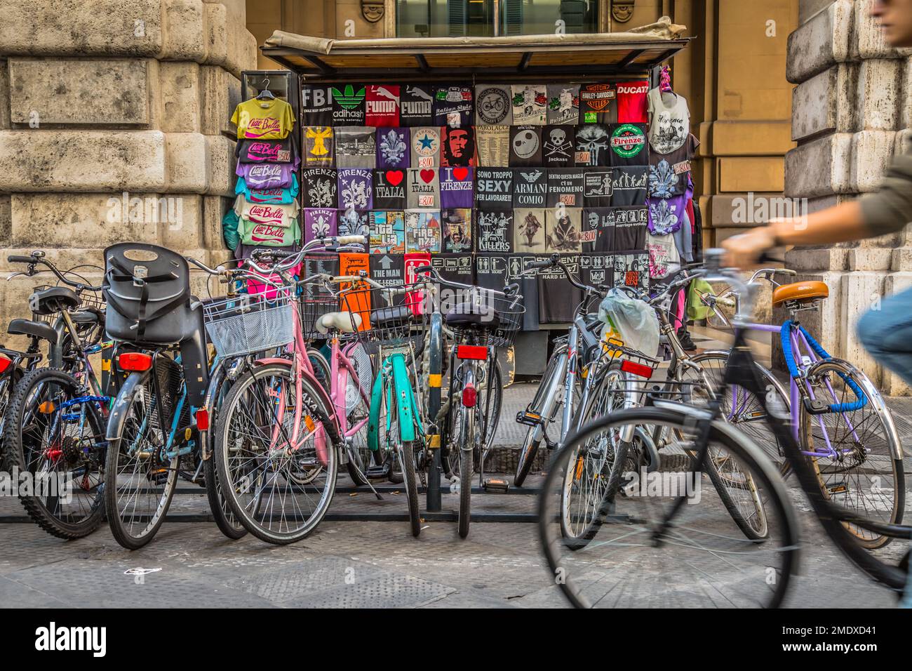 Biciclette parcheggiate di fronte allo stand della maglietta souvenir a Firenze, Toscana, Italia. Foto Stock