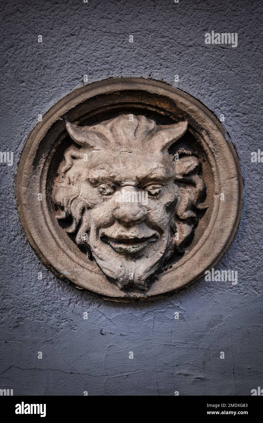 Faccia del Diavolo con il cattivo sorriso rilievo di pietra, piccola decorazione creepy su portico casa storica nella città vecchia di Danzica città in Polonia. Foto Stock