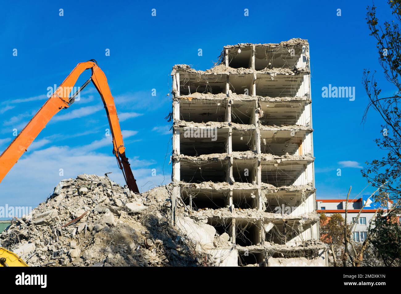 Demolizione del vecchio edificio con sloopkraan contro cielo nuvole blu. Foto Stock