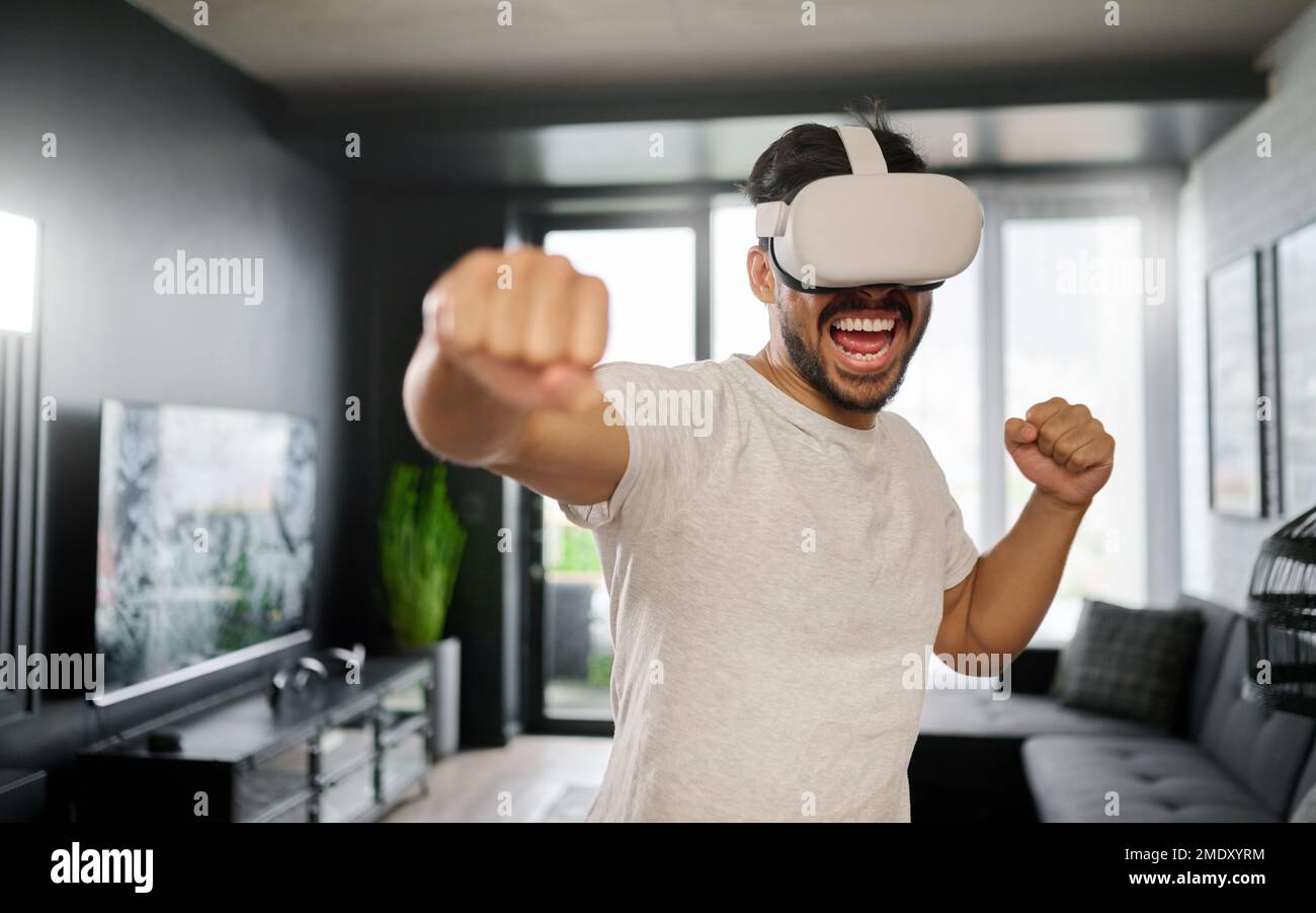 VR, arrabbiato e pugilato uomo con gli occhiali, allenarsi per un combattimento e una partita. Sport digitali futuristici e punch di gamer mentre giochi in un gioco potenziato Foto Stock