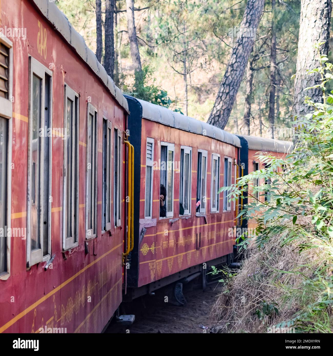 Toy Train in movimento su pendii di montagna, bella vista, una montagna laterale, una valle laterale che si sposta sulla ferrovia per la collina, tra verde foresta naturale. Giocattolo Foto Stock