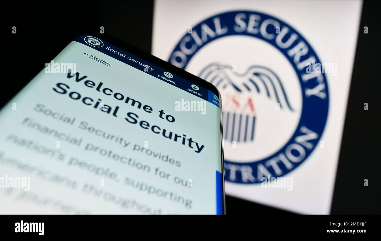 Telefono cellulare con pagina web della US Social Security Administration (SSA) sullo schermo di fronte al sigillo. Messa a fuoco in alto a sinistra del display del telefono. Foto Stock