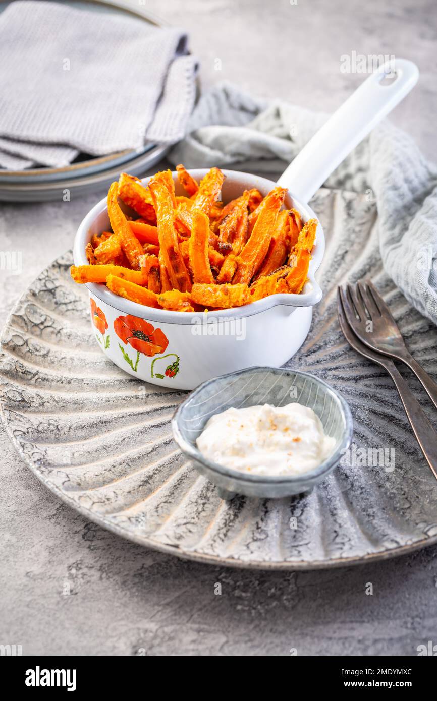 Patata dolce fatta in casa e patatine fritte di carote con parmigiano e salsa di yogurt al limone Foto Stock