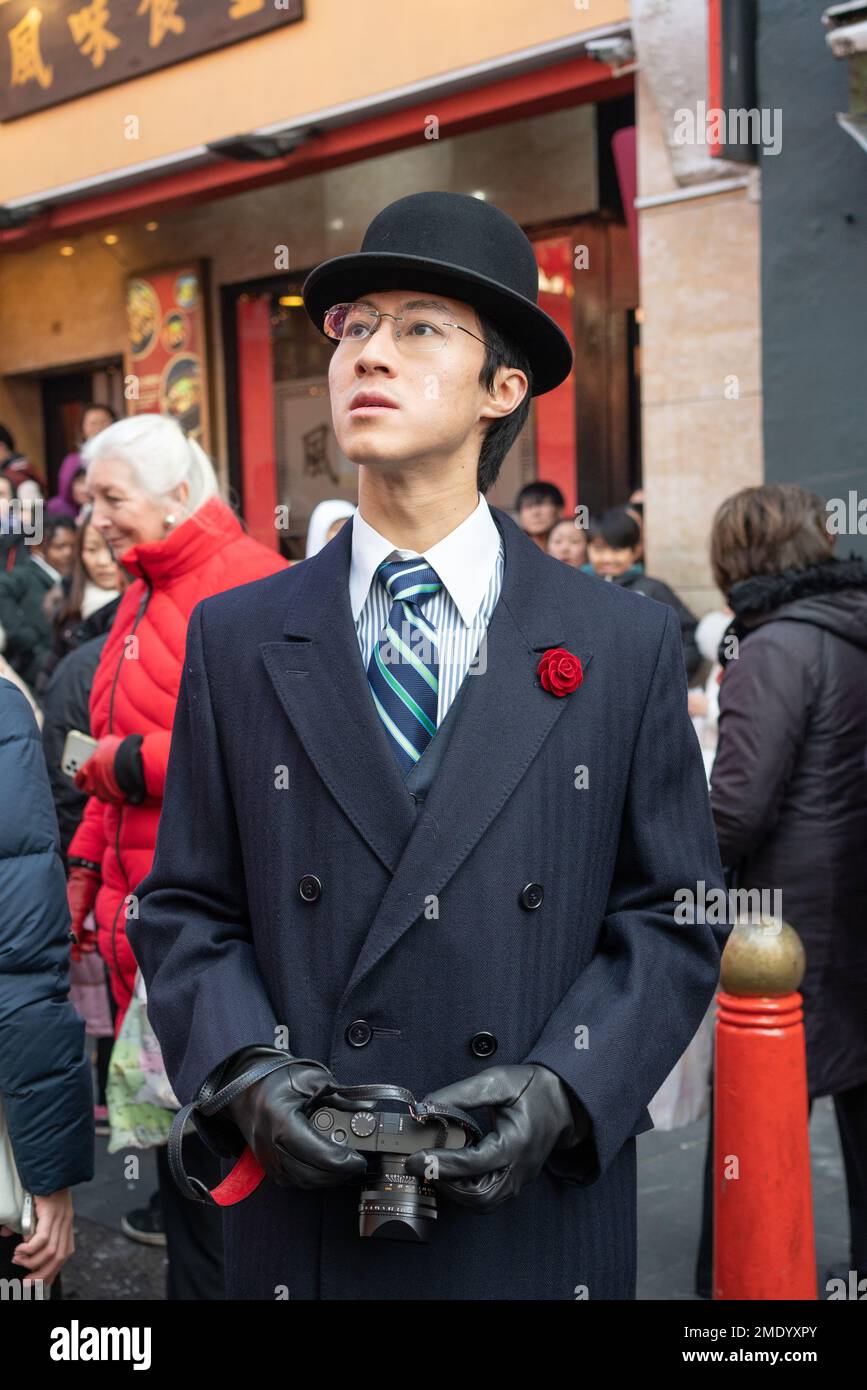 Uomo asiatico in tuta e cappello da bowler festeggia il nuovo anno nella città cinese di Londra, Inghilterra, Regno Unito Foto Stock