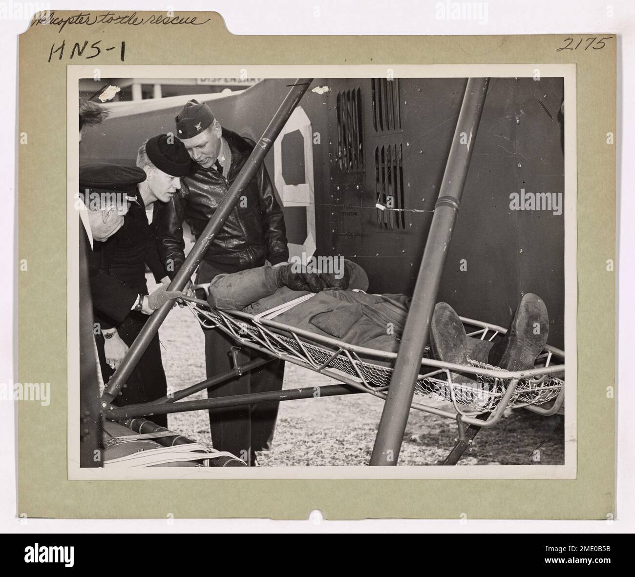 Un elicottero della Guardia Costiera dimostra la sua capacità di eseguire salvataggi verticali in mare. Gli assistenti allontanano con attenzione una vittima dall'elicottero, mostrando il ruolo chiave dell'aereo nelle missioni di ricerca e salvataggio. Foto Stock