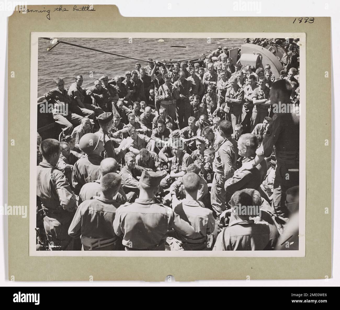 Gli ufficiali statunitensi e le guardie costiere discutono i preparativi finali per il loro ruolo in un'invasione a bordo di un trasporto da combattimento con equipaggio della Guardia Costiera diretto verso la terraferma italiana. L'attacco è accuratamente coordinato dai leader dell'esercito, della marina e della guardia costiera. Foto Stock