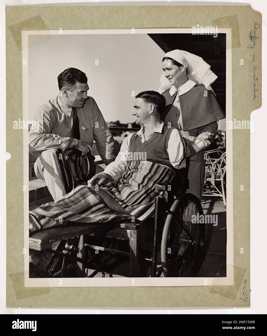 L'ex campione dei pesi massimi Jack Dempsey, ora comandante della Guardia Costiera, incontra un soldato australiano ferito nel Pacifico meridionale. Dempsey, visitando basi e ospedali remoti, fornisce supporto e motivazione ai soldati che ha addestrato, offrendo incoraggiamento e discutendo strategie di combattimento. Foto Stock