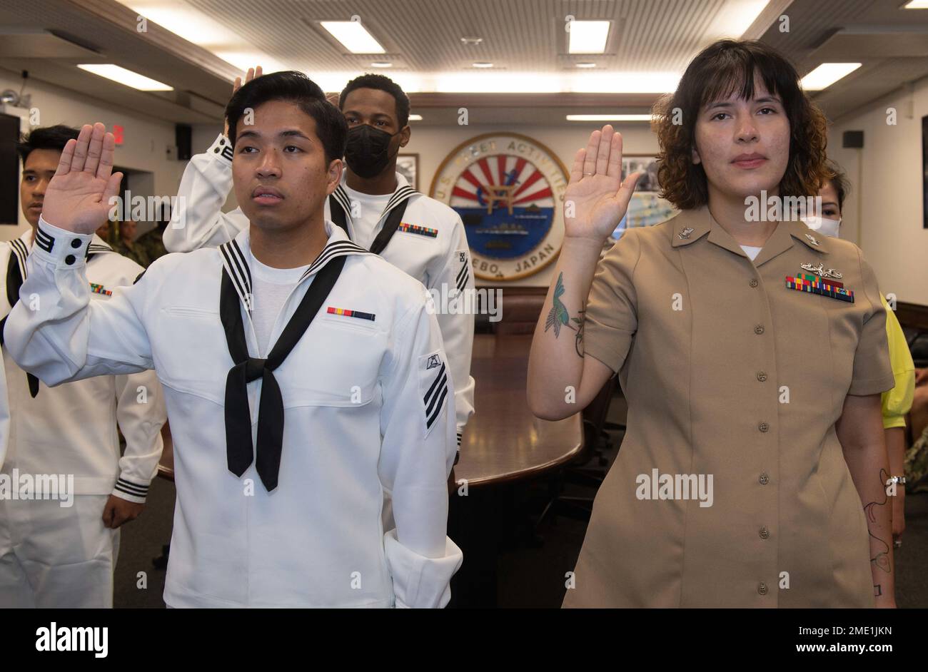 I marinai e i familiari con sede a Sasebo si impegnano a dare il giuramento di naturalizzazione di Allegiance agli Stati Uniti d'America durante una cerimonia di naturalizzazione al Comandante, Fleet Activities Sasebo (CFAS) 27 luglio 2022. STATI UNITI Citizenship and Immigration Services and Region Legal Service Office Western Pacific ha collaborato per condurre la cerimonia di naturalizzazione al CFAS consentendo ai marinai di diventare cittadini degli Stati Uniti. Foto Stock