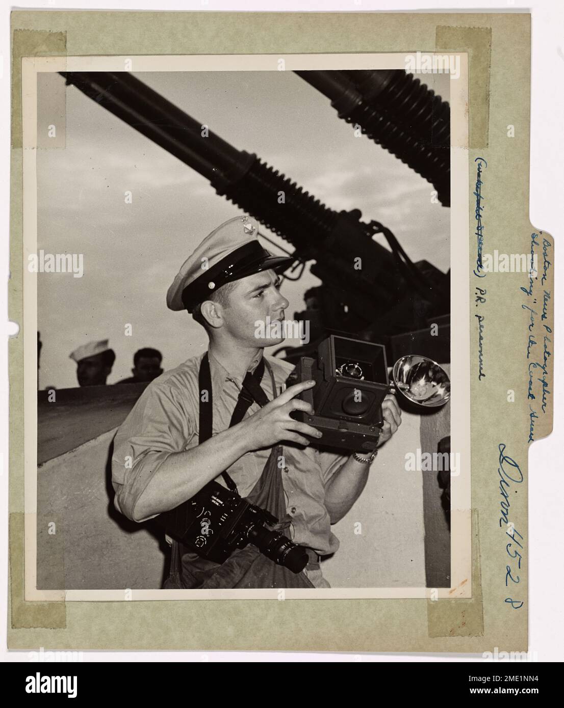 Il fotografo di combattimento della Guardia Costiera Bob Dixon, precedentemente con il Boston Herald, cattura le immagini a bordo di una nave da trasporto della Guardia Costiera che muove rinforzi. Dixon utilizza macchine fotografiche per documentare la vita a bordo e le attività in tempo di guerra. Il suo lavoro serve come registrazione visiva del ruolo della Guardia Costiera nel Pacifico e nei teatri europei durante la seconda guerra mondiale Foto Stock