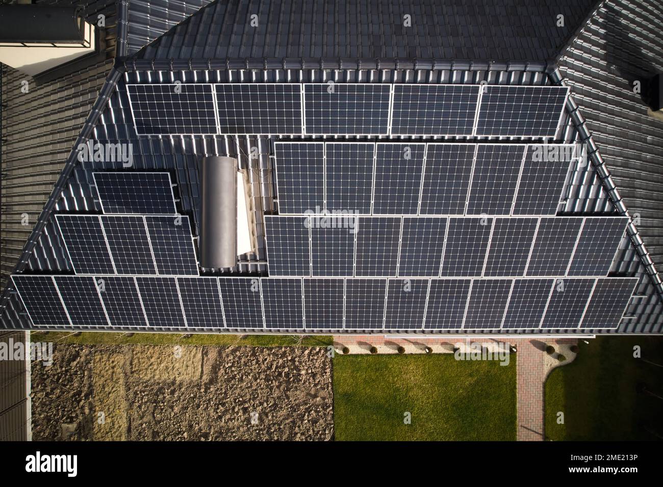Casa residenziale con impianto solare fotovoltaico sul tetto. Tetto da costruzione con moduli solari per la generazione di energia elettrica per effetto fotovoltaico. Concetto di risorse sostenibili per l'alimentazione. Foto Stock