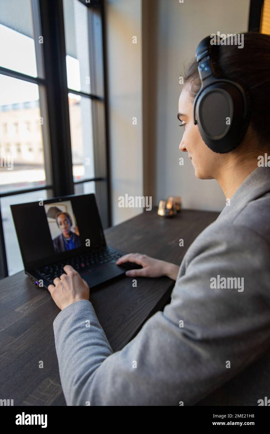 Due colleghi videochattano al lavoro durante una riunione online Foto Stock