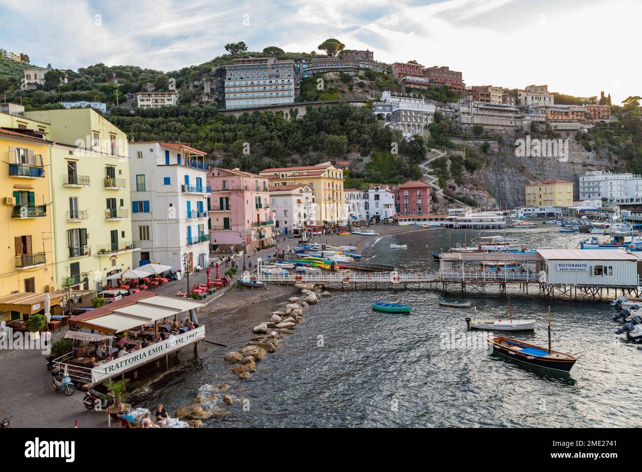 Vista delle persone che mangiano all'aperto e delle barche attraccate lungo Marina grande a Sorrento, Campania, Italia. Foto Stock