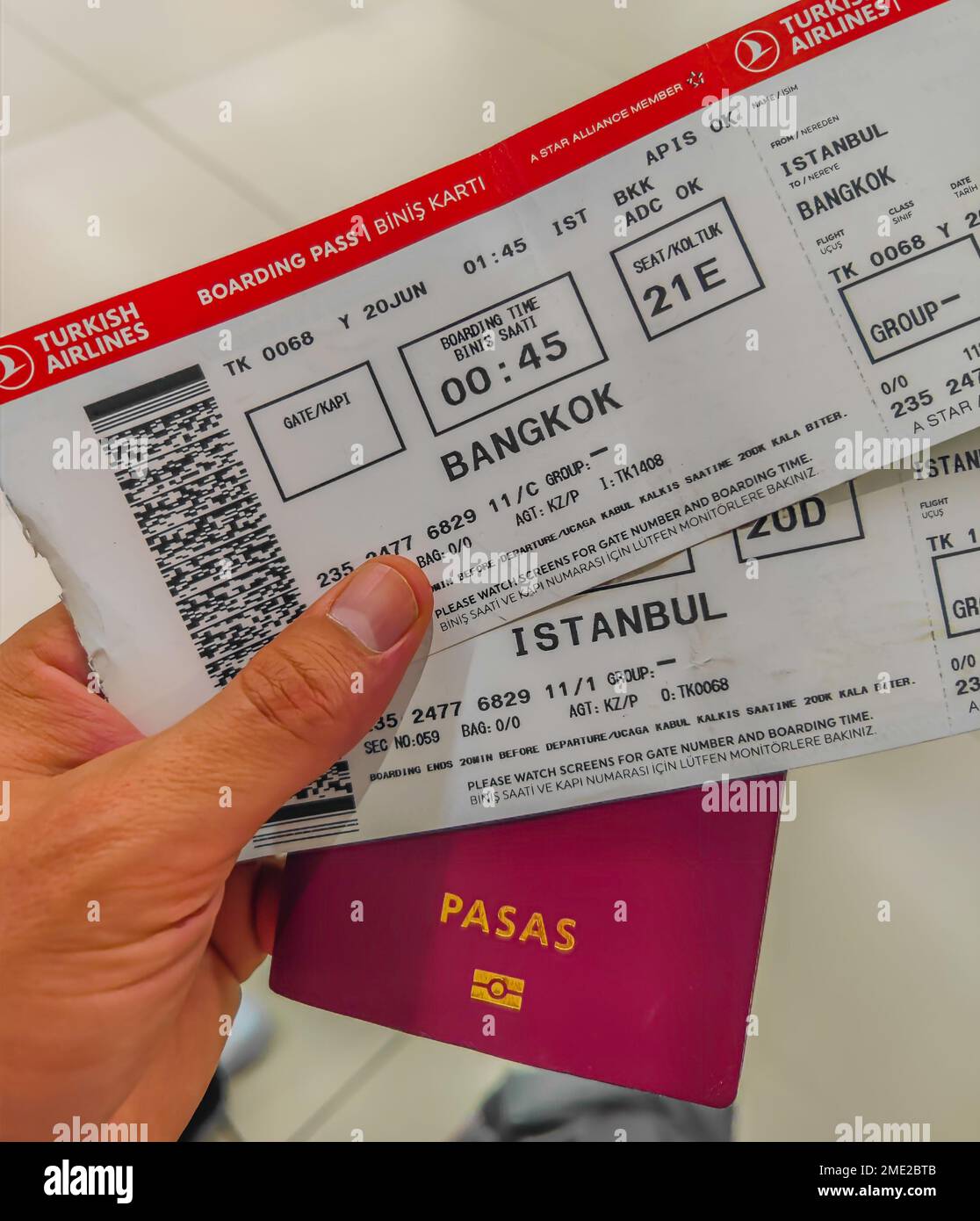 01 23 2023 - Vilnius, Lituania. Uomo che tiene in mano il passaporto e la carta d'imbarco delle compagnie aeree turche per il volo verso Istanbul e Bangkok Foto Stock