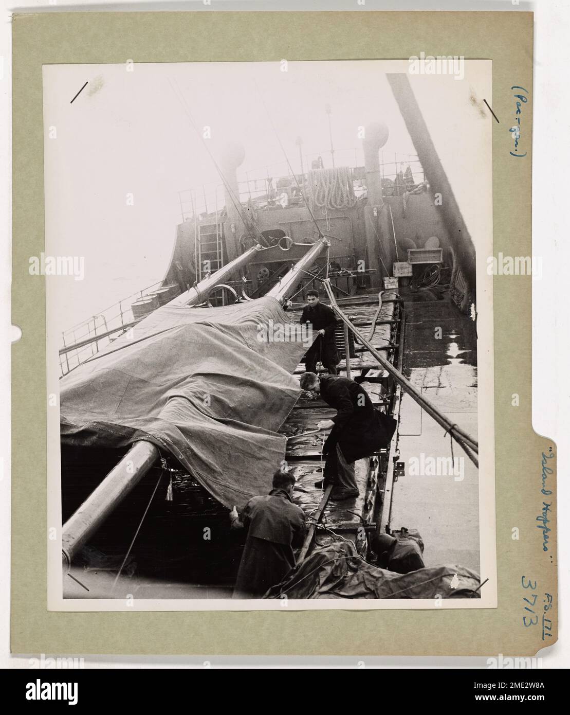 Questa immagine mostra le guardie costiere che si mettono in sicurezza i teloni su una nave dell'esercito statunitense FS (Freight Supply) nel Pacifico meridionale, mentre la nave combatte attraverso una pattuglia. La Guardia Costiera svolge un ruolo fondamentale nel sostenere le operazioni dell'esercito nel Pacifico, garantendo che la logistica e le forniture raggiungano le truppe. Foto Stock