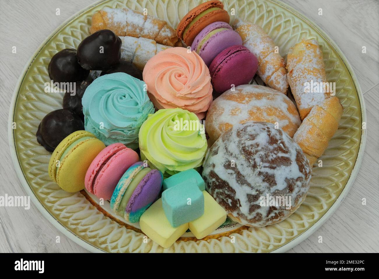 Dolci in piatto per le vacanze. Marshmallows, amaretti, dolci e caramelle al cioccolato in un piatto grande. Foto Stock