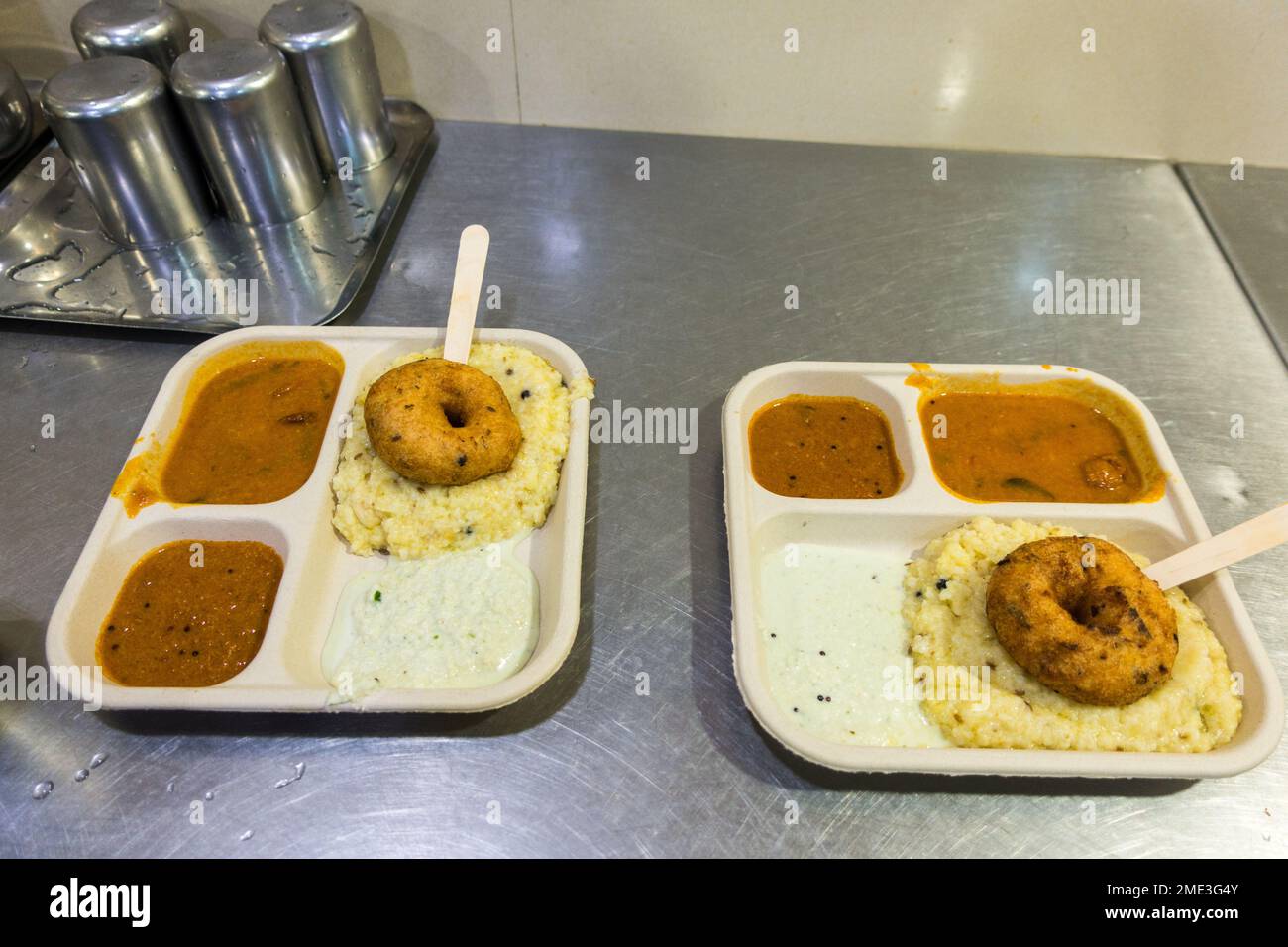 Tavolo con due piatti di Pongal e vada a colazione dell'India del Sud Foto Stock