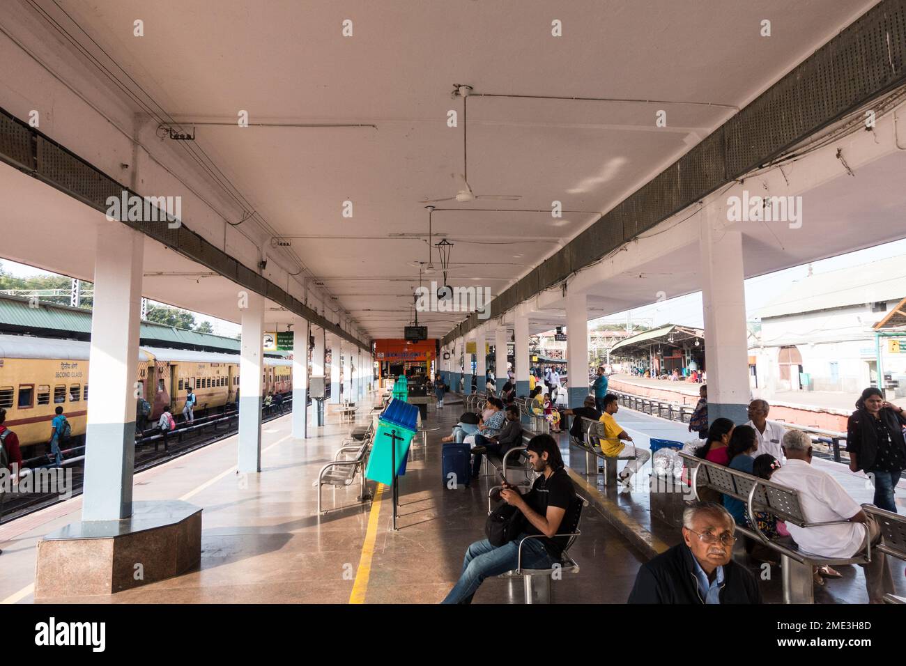 Stazione ferroviaria indiana con posti a sedere e area coperta per l'attesa sul binario Foto Stock