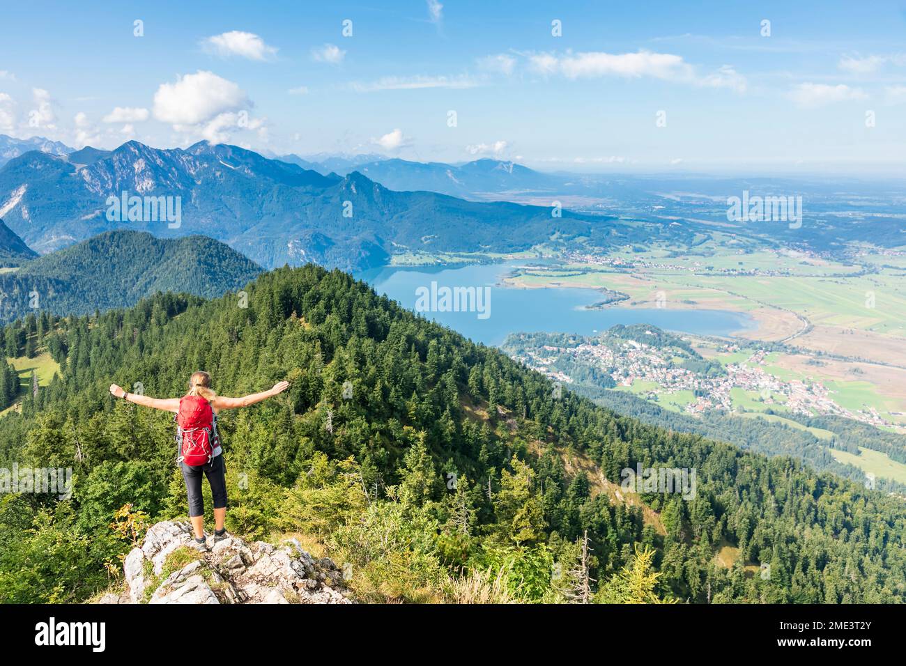 Germania, Baviera, Kochel am See, escursionista femminile in piedi in cima alla montagna con lago Kochelsee sullo sfondo Foto Stock