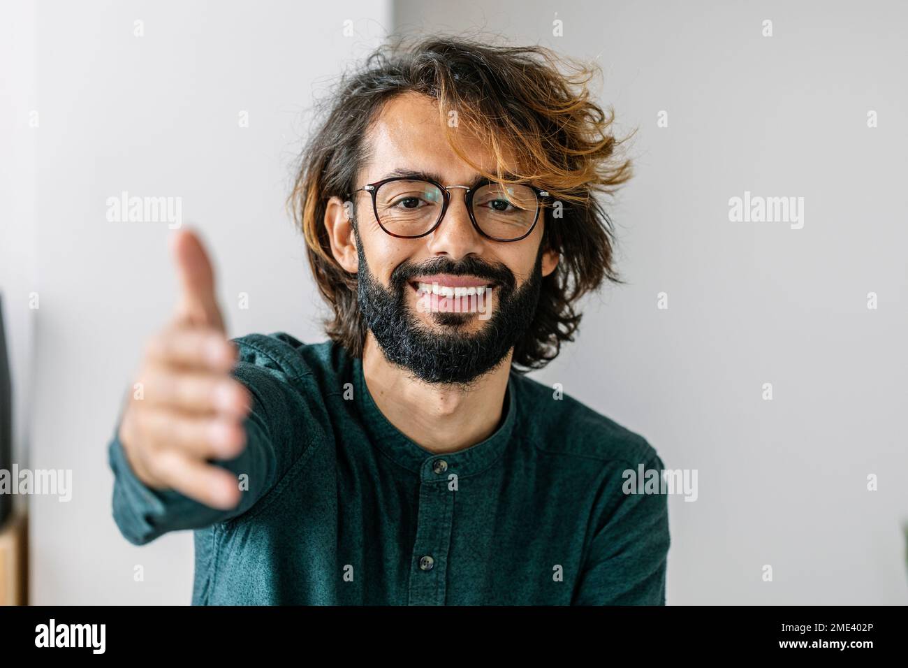 Felice freelancer raggiungere per handshake in ufficio Foto Stock