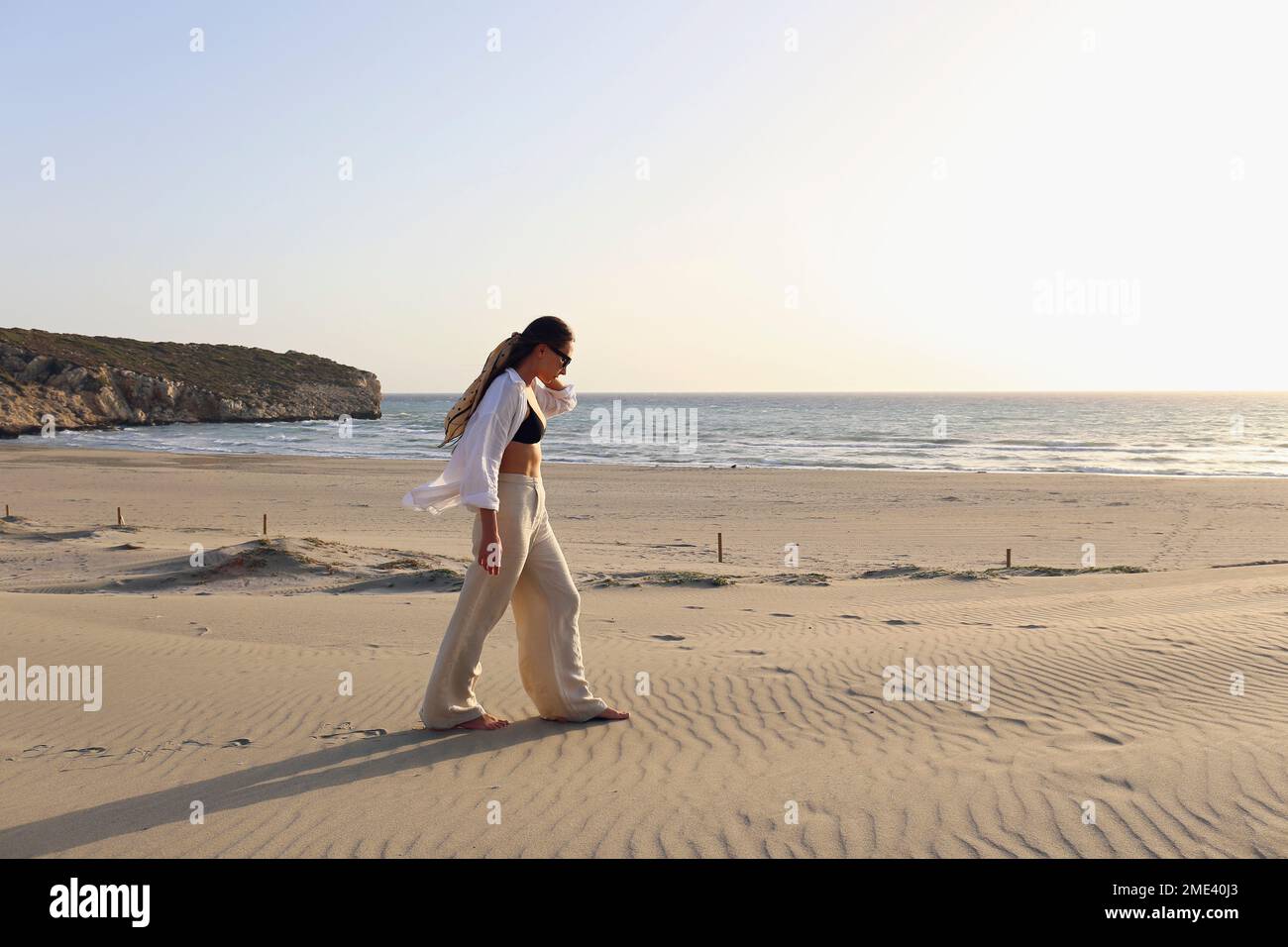 Giovane donna che cammina sulla sabbia in spiaggia, Patara, Turkiye Foto Stock