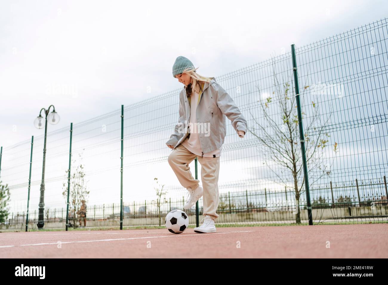 Ragazza adolescente che gioca con la palla di calcio Foto Stock