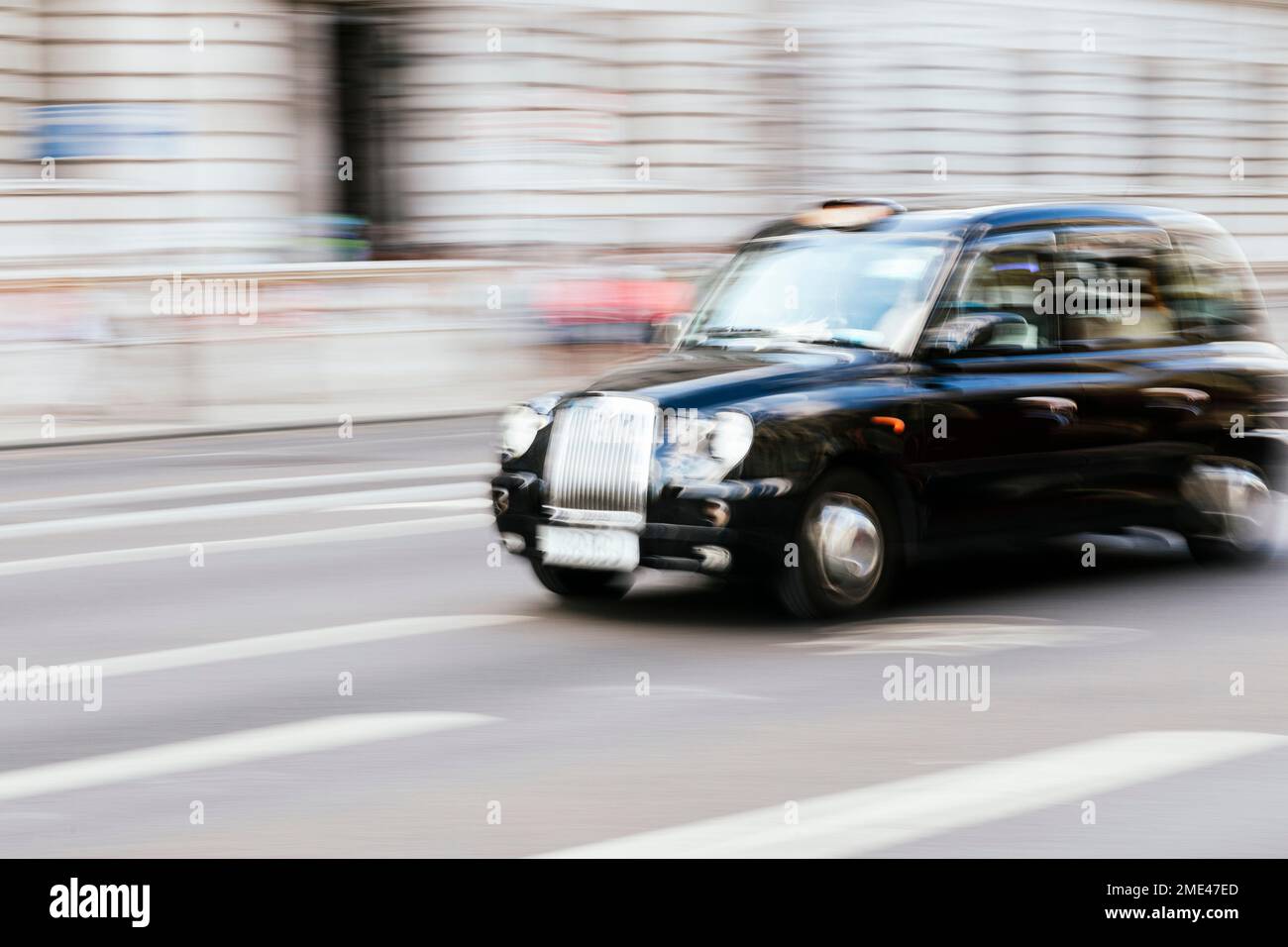 Regno Unito, Inghilterra, Londra, movimento sfocato di taxi guida lungo la strada della città Foto Stock