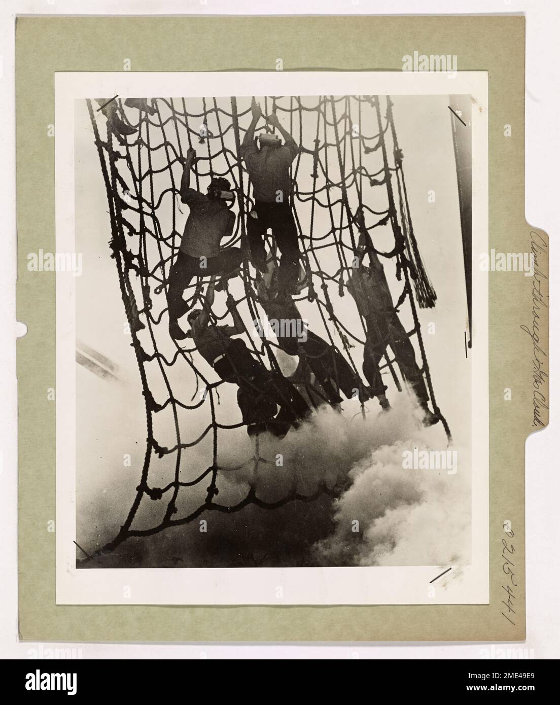 Le guardie costiere scalano le reti di atterraggio mentre le nuvole di gas lacrimogeni riempiono l'aria intorno a loro, dimostrando gli intensi esercizi di addestramento progettati per prepararli al controllo antisommossa, alla guerra urbana e agli ambienti pericolosi. Foto Stock