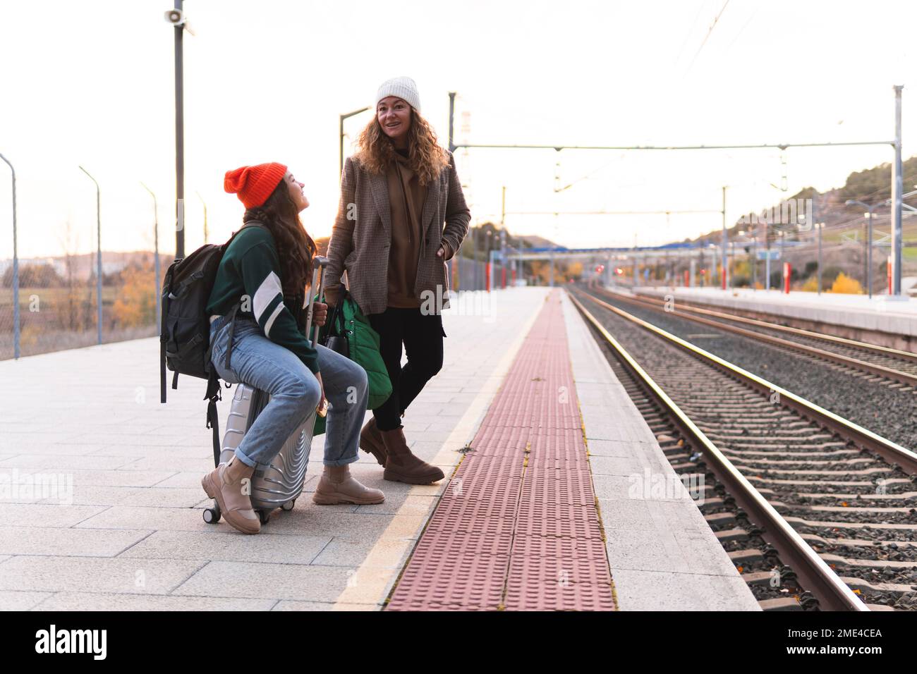 Madre e figlia in attesa alla piattaforma ferroviaria Foto Stock