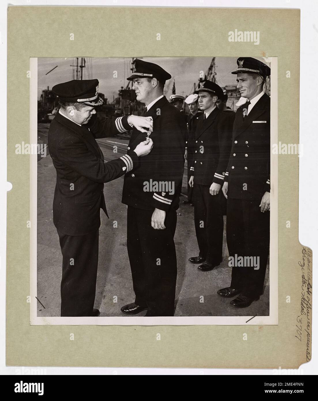Il tenente della Guardia Costiera Henry K. Rigg riceve la Bronze Star Medal per la sua eccezionale leadership durante l'assalto alle spiagge della Normandia. La medaglia fu consegnata dal comandante A. C. Unger in riconoscimento del ruolo di Rigg come comandante della LCI (L)88. Foto Stock