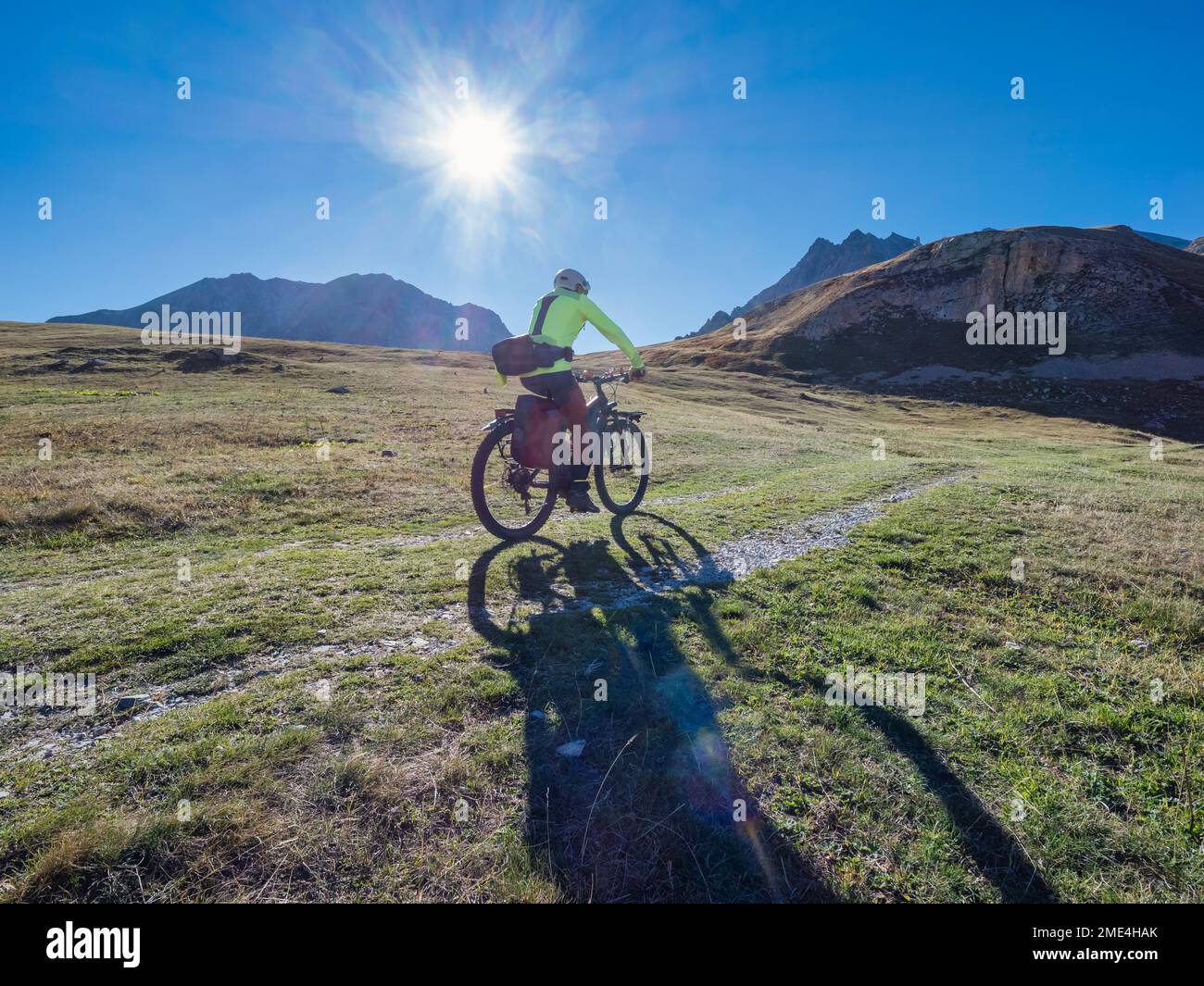 Uomo in mountain bike nelle giornate di sole sotto il cielo blu del Parco Nazionale della Vanoise, Francia Foto Stock