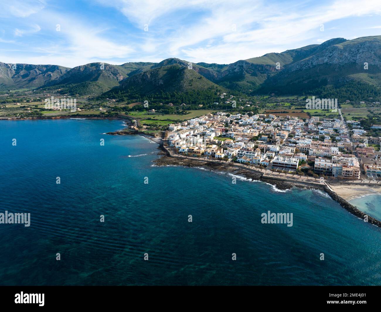 Veduta aerea della città e delle montagne dal mare, Colonia de Sant Pere, Arta, Maiorca, Spagna Foto Stock