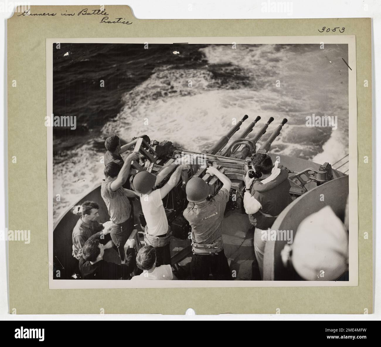 Questa immagine mostra le guardie costiere che si preparano alla battaglia affilando le loro abilità di tiro con una batteria da 40 mm. Questa pratica era essenziale per mantenere la prontezza nella difesa contro potenziali aerei nemici o attacchi di superficie durante la seconda guerra mondiale. Foto Stock