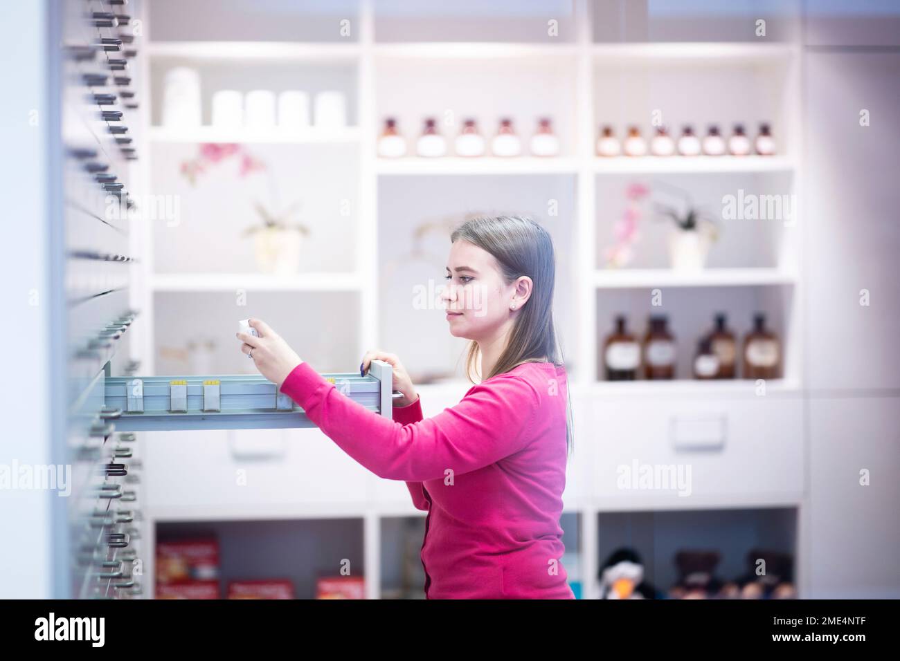 Giovane farmacista che esamina il medicinale presso il negozio di farmacia Foto Stock