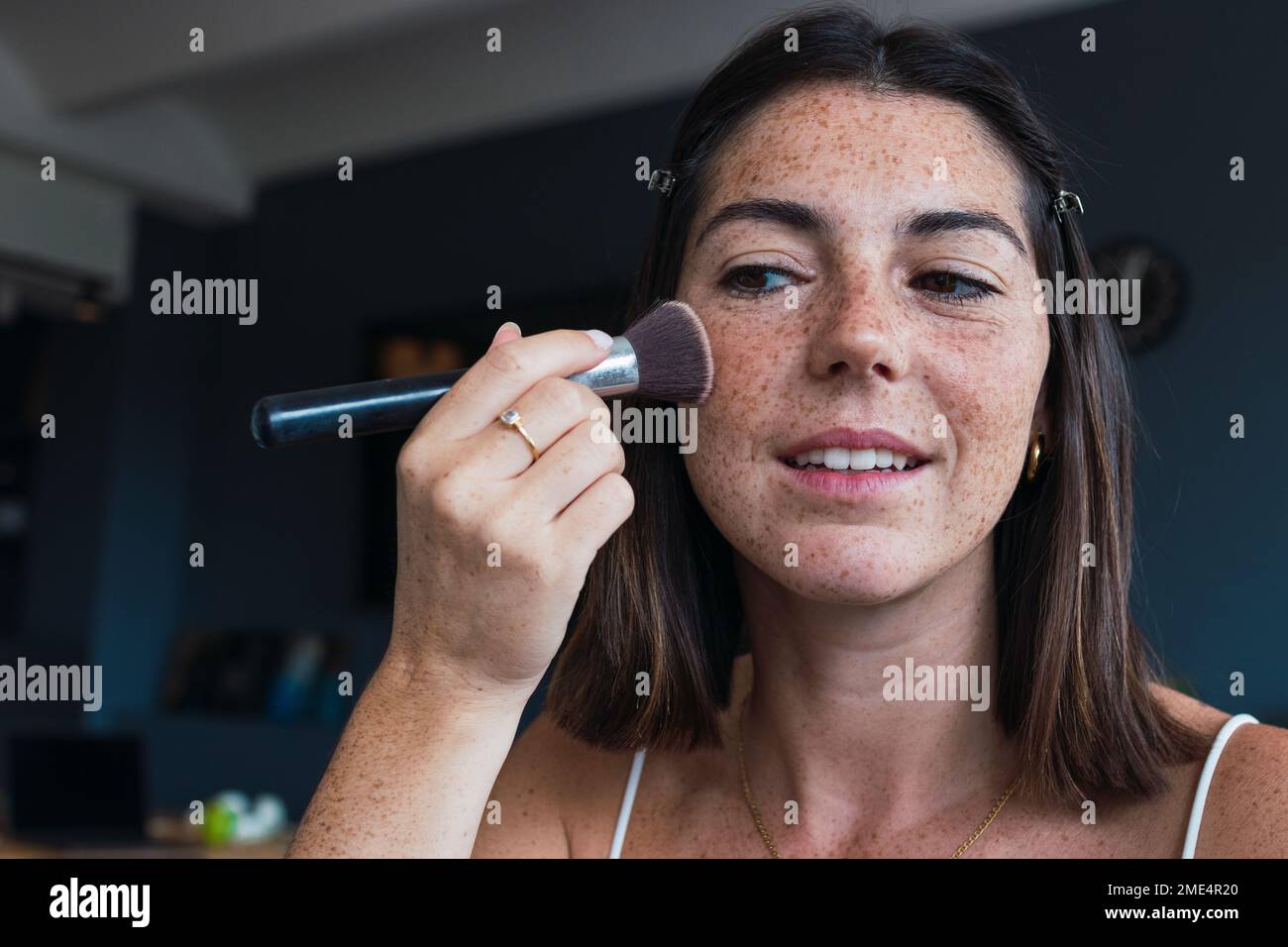 Donna con faccia di reckle che applica il trucco nel paese Foto Stock