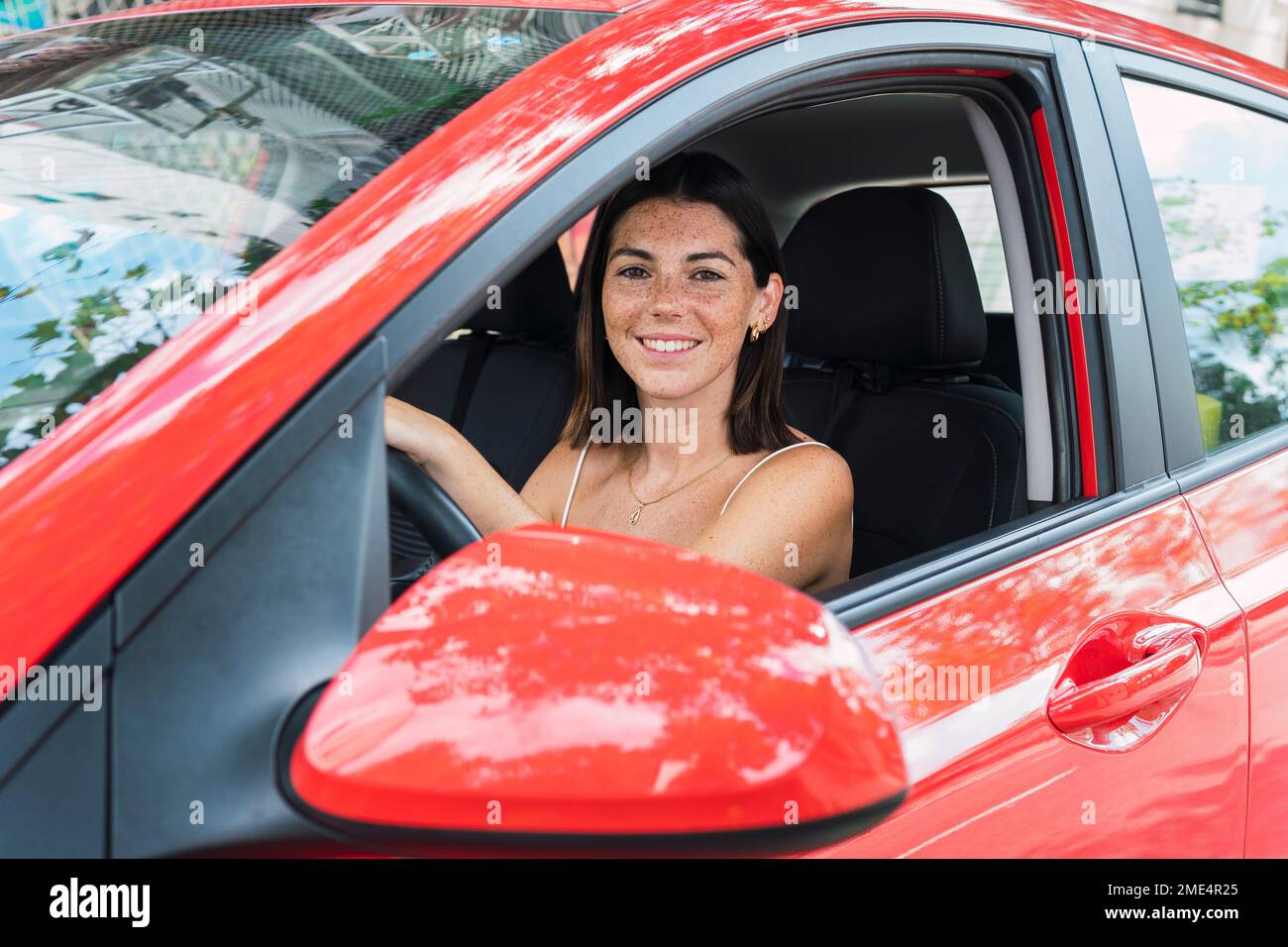 Felice giovane donna alla guida di auto Foto Stock