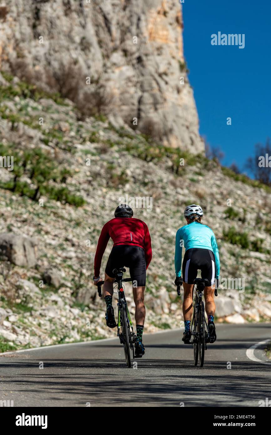 Ciclisti maturi che indossano caschi in bicicletta davanti alla roccia Foto Stock
