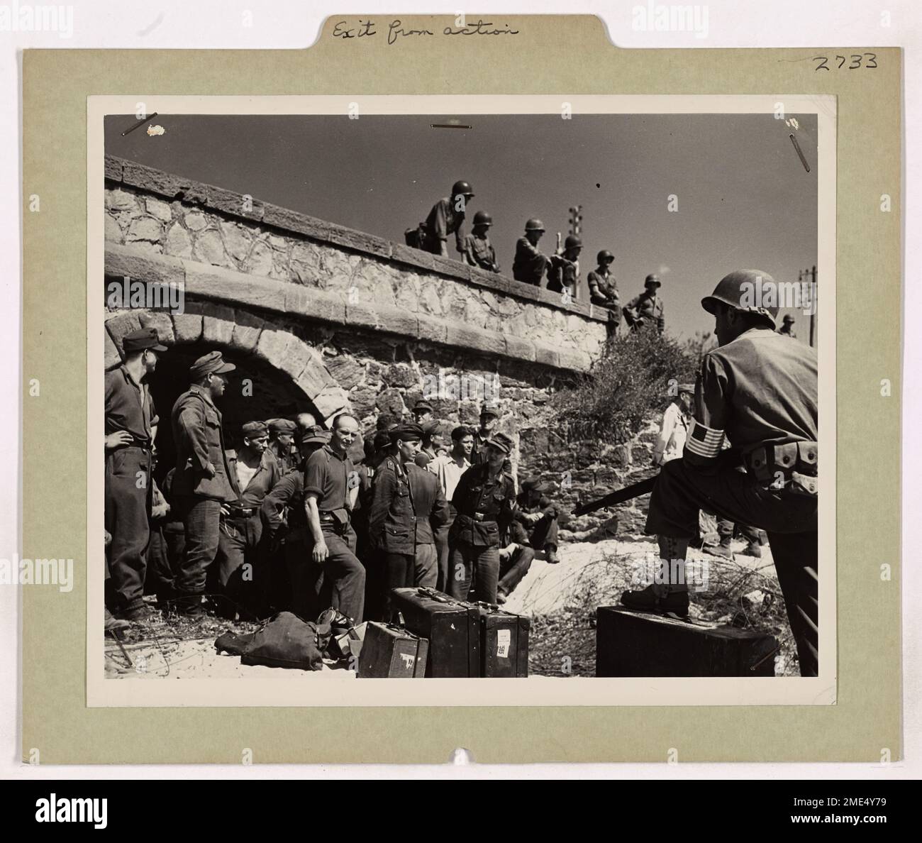 Questa immagine mostra i soldati tedeschi catturati dalla sedicesima Divisione Panzer dopo l'assalto anfibio nel sud della Francia. Attendono il trasferimento dal campo di battaglia, sotto la sorveglianza della fanteria americana, per essere allontanati dal teatro di guerra europeo. Foto Stock